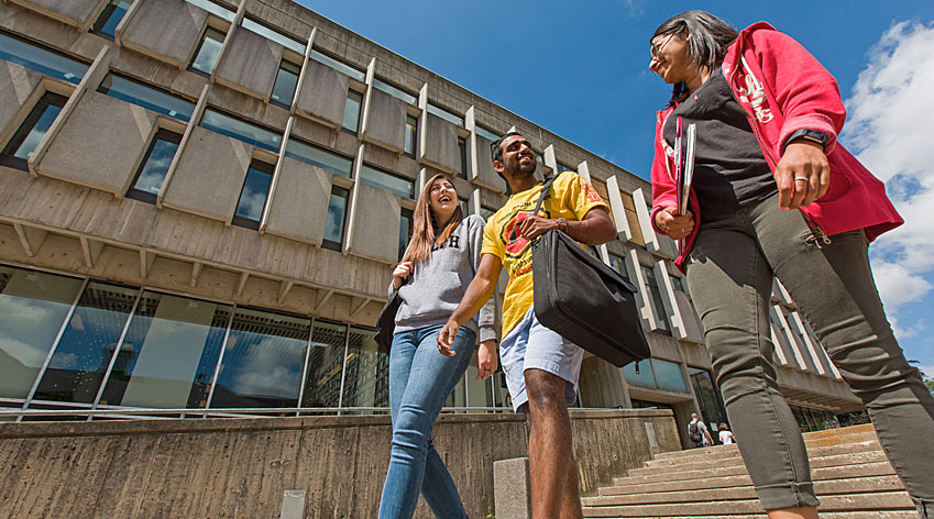 Students walking past campus buildings