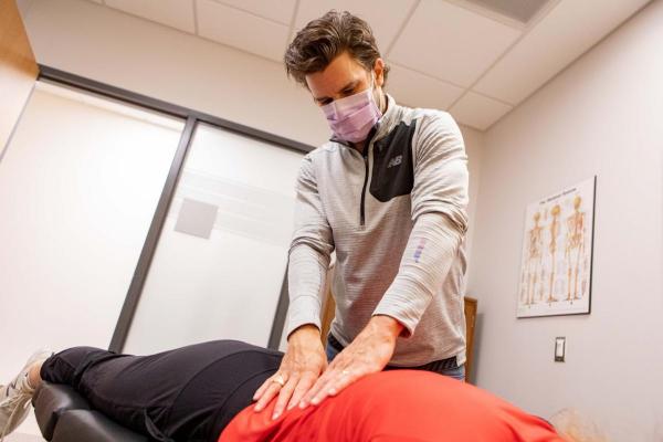 Chiropractor in Guelph adjusting a female Guelph Gryphons varsity hockey player who is laying face down on the the table at the University of Guelph Health and Performance Centre (HPC)