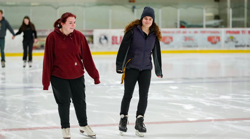 Two women skating in the indoor rink