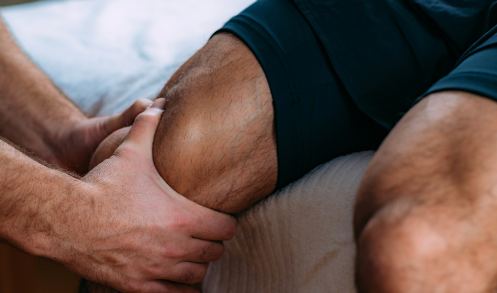 Health and Performance Centre HPC Guelph Massage Therapy. Massage therapist massaging man's knee after a sport injury